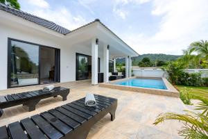 a villa with a swimming pool and a house at Thala Villa Koh Samui in Nathon Bay