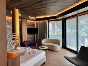 a room with a bed and a couch and a chair at Alevic Hotel Sirmione in Sirmione