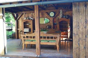 a wooden house with a table and a clock on the wall at Penzion Zaječí důl in Mníšek