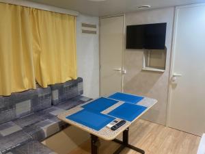 オリヴェーリにあるBaia del Principe MobilHomeのテーブルと壁にテレビが掛かっている部屋