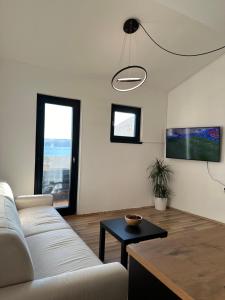 a living room with a white couch and a table at Apartment Diva Maria in Stinica