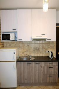 a kitchen with white cabinets and a sink at Cozy apartment in Jeruzalė in Vilnius +11 photos