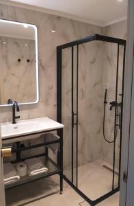 a bathroom with a shower and a sink and a mirror at Triena Rooms in Mythimna +21 photos
