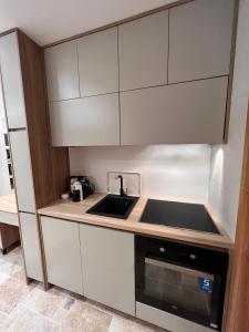 a small kitchen with white cabinets and a sink at Casa Calma in Bar