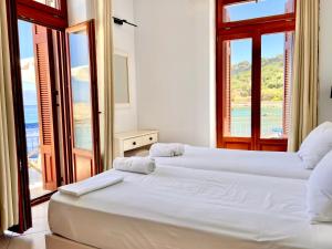 two beds in a room with a view of the ocean at Xenios Zeus Rooms in Koroni