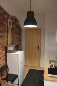 a kitchen with a white refrigerator and a black light at Stargard Apartamenty Centrum in Stargard +9 photos