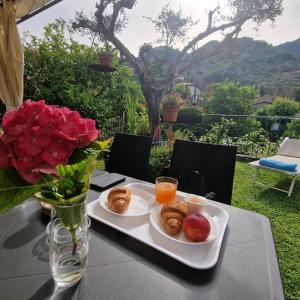 a tray of breakfast foods on a table with roses at jasmine cottage in Luni