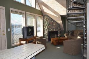 sala de estar con TV y chimenea en Retreat Wilderness Inn, en Nimpo Lake