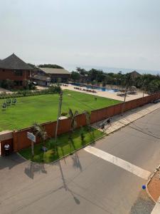 een lege straat naast een park met palmbomen bij Appart city in Tokpokondji