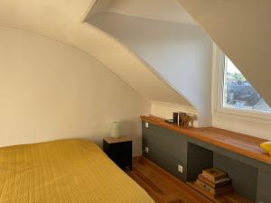 une chambre avec un lit jaune et une fenêtre dans l'établissement Mirabelle Second, à Bagnères-de-Bigorre