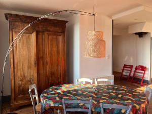 une salle à manger avec une table avec des chaises et une lampe dans l'établissement Mirabelle Second, à Bagnères-de-Bigorre