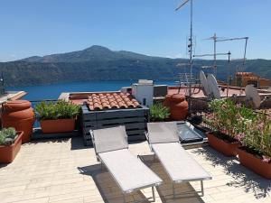 a patio with chairs and a view of the water at Loft 51 Castel Gandolfo in Castel Gandolfo