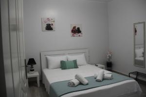 a bedroom with a white bed with towels on it at Apartment Patra Greece in Patra