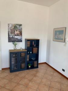 a room with a blue book shelf and a table at Sunshine on the Lake Apartment in Padenghe sul Garda