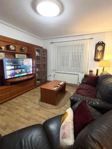 a living room with a couch and a tv at Piso 5 min a pie del centro parking gratis in Valladolid