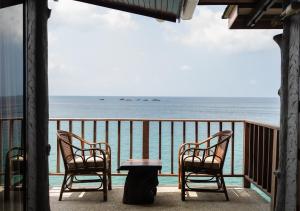 two chairs and a table on a balcony overlooking the ocean at Dusit Buncha Koh Tao by Riya Group in Ko Tao