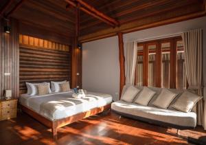 a bedroom with a large bed and a couch at Dusit Buncha Koh Tao by Riya Group in Ko Tao