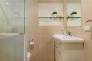 a bathroom with a sink and a toilet and a mirror at Peaceful 4-Bedroom Vineyard Retreat in Hahndorf in Hahndorf +48 photos