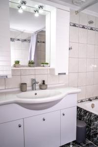 un bagno bianco con lavandino e specchio di The Olive House a Dhíkella