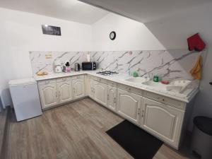 a kitchen with white cabinets and marble counter tops at maison in Saivres