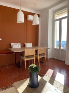 ein Esszimmer mit Tisch und Stühlen und einem Fenster in der Unterkunft COULEUR PARFUM - VUE MER avec Balcon PARKING GRATUIT in Grasse