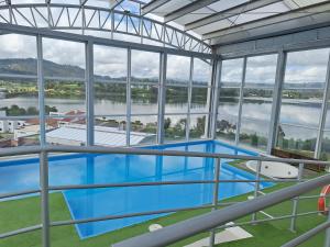 a view of a swimming pool in a building with windows at Fabuloso Apartaestudio in Paipa