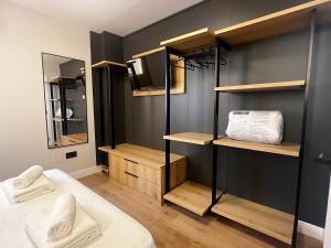 a room with a bed and some shelves and a television at Nómada Orzán in A Coruña