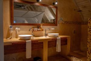 a bathroom with two sinks and a mirror at Jambiani Villas in Jambiani +59 photos
