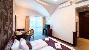 Postel nebo postele na pokoji v ubytování Hotel Tihany Átrium