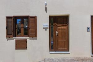 a building with wooden doors and windows on it at B&B Victoria in Laurenzana