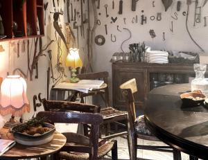 a dining room with tables and chairs and a wall covered in knives at Stone Oven House in Rorá