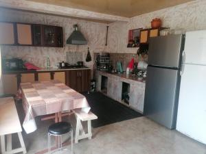 una cucina con tavolo e frigorifero di Guest House GIA - Bagrationi St # 42 a Kobuleti