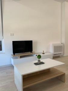 a white living room with a tv and a table at E&M Apartman in Struga