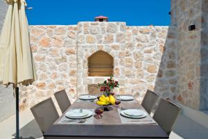 a table with a bowl of fruit on it next to a stone wall at Inn Villas in Fethiye
