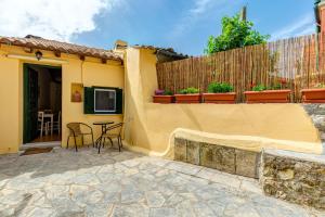 a patio of a house with a table and chairs at Village Sense by Corfu Escapes in Corfu