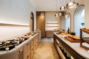 a large kitchen with a buffet line with food at De Tuilerieën - Small Luxury Hotels of the World in Bruges