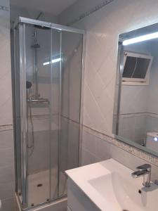 Un baño con ducha, lavabo y espejo. en Altafulla, primera linea de mar con acceso directo a la playa, en Altafulla 37 fotos más
