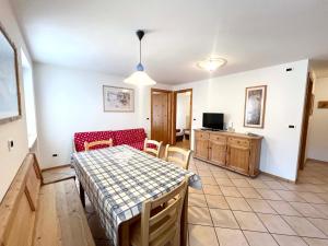 eine Küche und ein Esszimmer mit Tisch und Stühlen in der Unterkunft Moena Appartamenti in Moena
