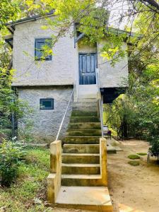 a set of stairs leading up to a house at Hotel Sigiriya Kele in Sigiriya