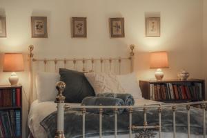 a bedroom with a bed with two lamps and books at Koolyangarra Cottage Adelaide Hills in Adelaide