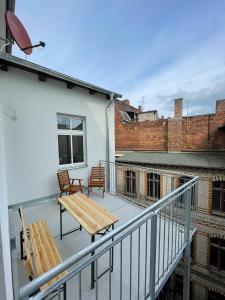 a balcony with a wooden table and chairs on a building at FeWo Luise mit 4-Zimmer, Balkon, 127qm in Görlitz