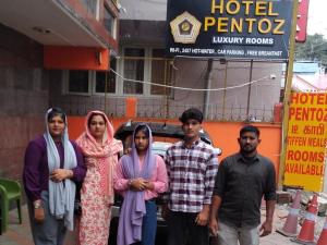 a group of people standing in front of a truck at Hotel PENTOZ - Rose Garden, Ooty in Ooty