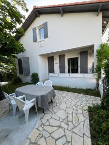 a patio with a table and chairs in front of a house at Maison 8 pers à 900 m de la mer au calme in Vaux-sur-Mer