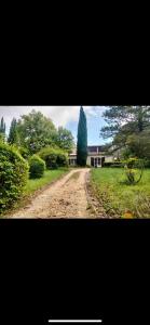 eine unbefestigte Straße vor einem Haus mit einem Baum in der Unterkunft Domaine Happyness en Ardèche in Le Teil