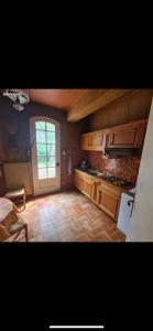 eine Küche mit Holzschränken und einem großen Fenster in der Unterkunft Domaine Happyness en Ardèche in Le Teil + 14 Fotos