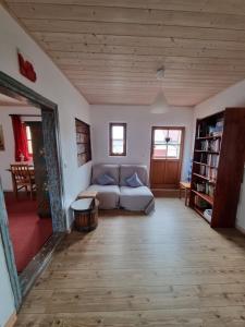 a living room with a couch and a book shelf at Ferienhaus Ederhof - Idyllischer Vierseithof, kinder- und hundefreundlich, Referenzen auf FeWo-direkt nachlesbar in Aidenbach