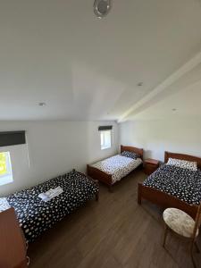 a room with three beds and two chairs in it at Casa La Molina in Burgos