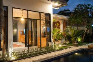 een huis met een zwembad ervoor bij Villa La Familia Dua in Canggu