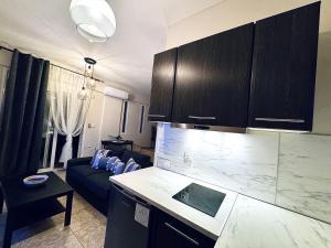 a kitchen and a living room with a couch at Sun Sight - Deluxe Infinity View Suites in Pefkochori