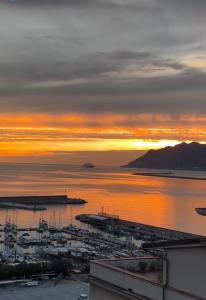 a sunset over a harbor with boats in the water at Mareluna Penthouse - Luxury Suites & Rooftop in Salerno